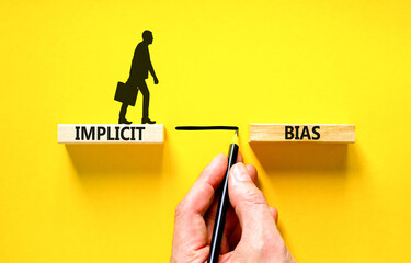 Implicit bias symbol. Concept words Implicit bias on wooden block. Beautiful yellow table yellow background. Businessman hand. Businessman icon. Business psychology implicit bias concept. Copy space. - obrazy, fototapety, plakaty