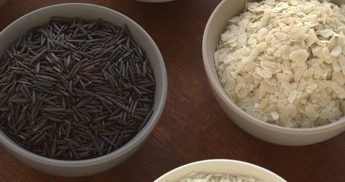 Different varieties of rice: wild, sona masoori, idli rice, flattened rice (poha), jasmine, basmati, arborio. Table spin. Seamless loop.