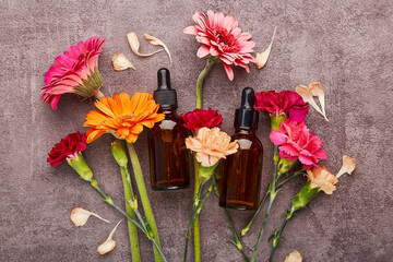 Dropper glass Bottle Mock-Up among flowers. Liquid pipette oil or serum elixir, hyaluronic acid. Beauty treatment