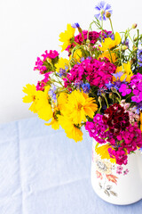 Beautiful summer bouquet of carnations, cornflowers and yellow chamomiles, part of home interior