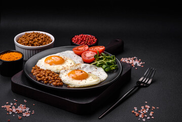 Delicious hearty breakfast consisting of two fried eggs, canned lentils and microgreens