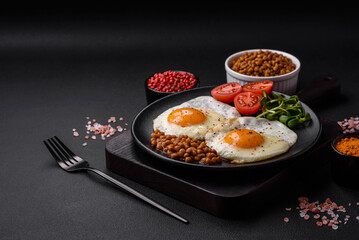 Delicious hearty breakfast consisting of two fried eggs, canned lentils and microgreens