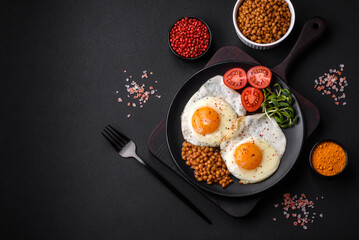 Delicious hearty breakfast consisting of two fried eggs, canned lentils and microgreens