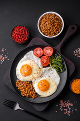 Delicious hearty breakfast consisting of two fried eggs, canned lentils and microgreens
