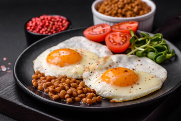 Delicious hearty breakfast consisting of two fried eggs, canned lentils and microgreens