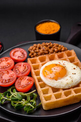 Delicious hearty breakfast consisting of a fried egg, Belgian waffle