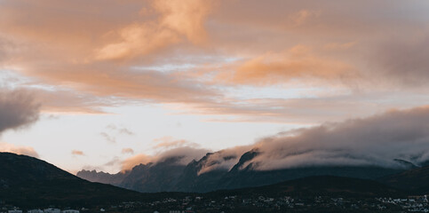 Fototapeta na wymiar Wolken brechen sich an Bergkamm während eines Sonnenuntergangs in Norwegen