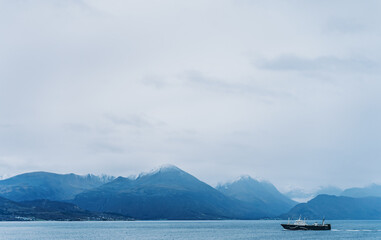 Fototapeta premium Ein Schiff fährt im Fjord an einem nebeligen Tag Richtung Hafen