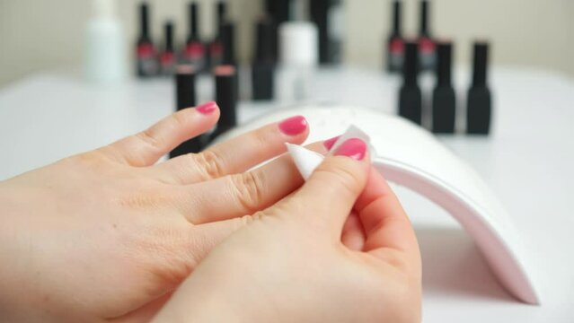 Erasing the sticky layer of the top gel polish, manicure and nail polish at home yourself.