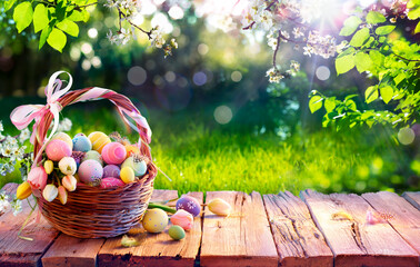 Easter Eggs In Basket On Aged Wooden Table In Spring Garden With Sunlight - 579143708