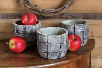 Ceramic pots and apples on a wooden table.