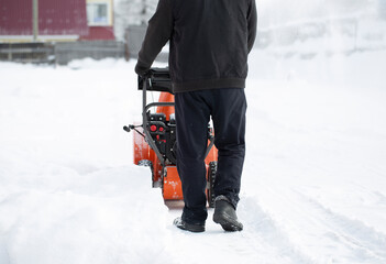 A portable snow blower powered by gasoline. Snow removal in winter.