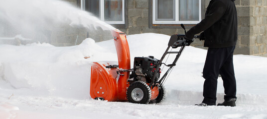 A portable snow blower powered by gasoline. Snow removal in winter.