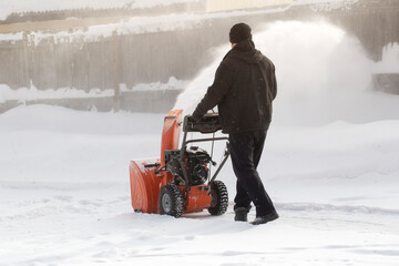A portable snow blower powered by gasoline. Snow removal in winter.