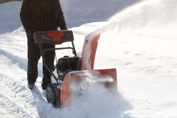 A portable snow blower powered by gasoline. Snow removal in winter.