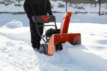 A portable snow blower powered by gasoline. Snow removal in winter.