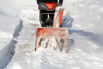 A portable snow blower powered by gasoline. Snow removal in winter.