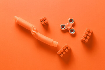 Spinner with Pop Tube and bricks on orange background