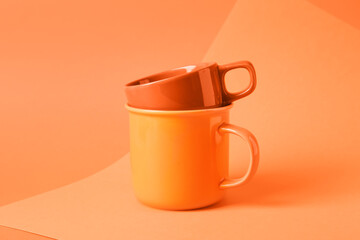 Ceramic mugs on color background