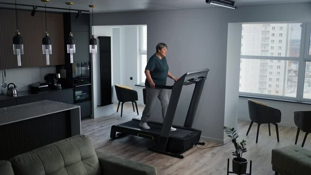 Home Fitness, Senior Woman Training On Treadmill In Living Room, Stay Healthy And Prevent Disease