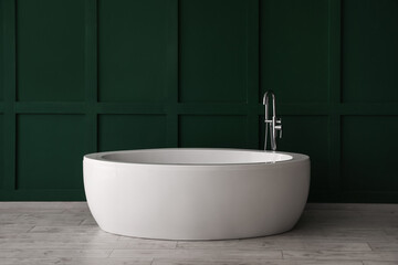 Naklejka na ściany i meble White bathtub near green wall