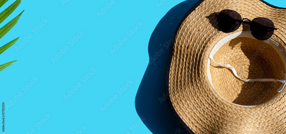 Wall mural Hat and sunglasses on blue background. Enjoy summer holiday concept.