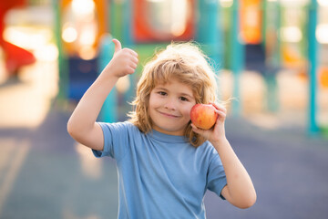 Fresh ripe apple for children. Happy teen boy with apple. Photo of child holding apple. Kid with apple.