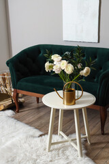Vase with ranunculus flowers on table in interior of living room