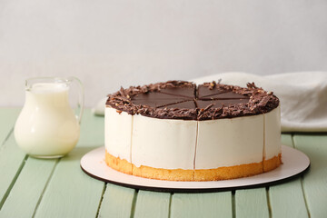 Tasty birds milk cake on color wooden table