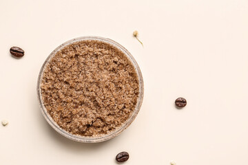 Jar of natural body scrub and coffee beans on light background