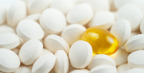 Fototapeta na wymiar Omega 3 softgel capsule against white pills.