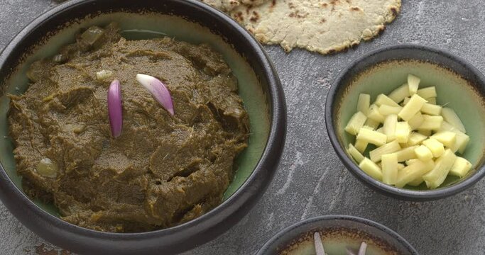Sarson ka saag traditional Indian dish with corn bread (Makki di roti) with shallots and ginger. Homemade food meal. Table spin.