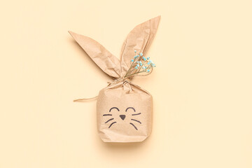Easter bunny gift bag with gypsophila flowers on beige background