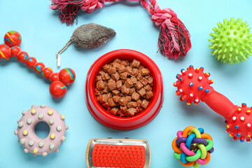 Composition with bowl of wet food and different pet care accessories on color background