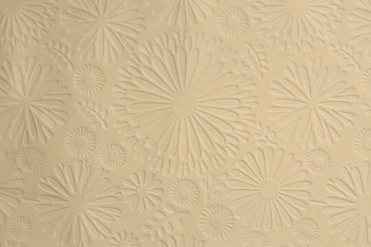 Scrapbook beige crumpled old craft paper blank with flower pattern. Texture relief copy space background.