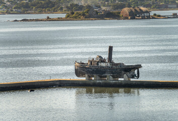 Abandoned wooden steam ship on stands on pier in Montevideo harbor in Uruguay - obrazy, fototapety, plakaty