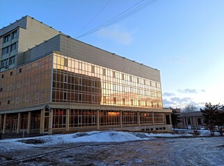 Obraz premium A glass building reflects the sunset on a frosty day.