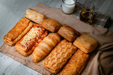 Bakery shop products - various kinds of baguette, bagel, donut, croissant, rolls, bread, puff pastry, powdered sugar delicious pies. Neutral background. Food from bakeries.