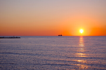 Fototapeta na wymiar merchant ship dry cargo ship is on the ocean at sunset