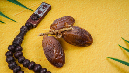 Dried date palm fruits or kurma with prayer beads muslim. Copy space for text