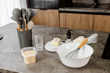 The set of kitchen utensils for cooking and baking on the table of a modern kitchen.