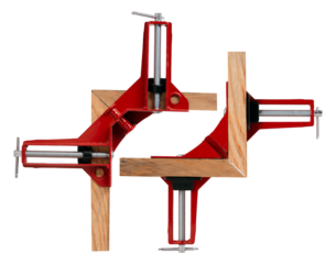 Gluing two slats at right angles in a special clamp, isolated background.