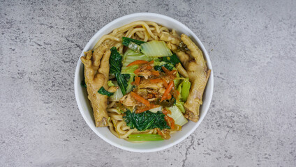 Mie ayam, bakmi ayam, or chicken noodle is a common Indonesian dish of seasoned yellow wheat noodles topped with diced chicken meat and chicken feet