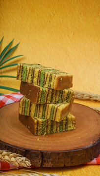 Stack of sliced lapis legit isolated on yellow background. Indonesian traditional cake