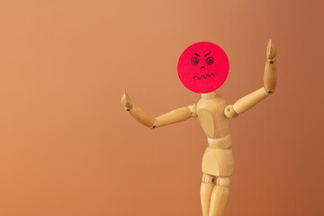 Wood model with anger  and fury concept, on brown background.