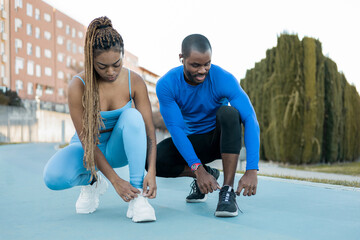 A dark-haired couple spends a happy afternoon playing sports outdoors, the black man and the black...