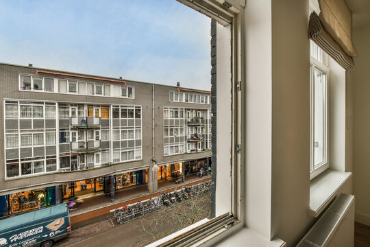 An Outside View From A Window With A Truck Parked In Front Of It And People Walking On The Street Below