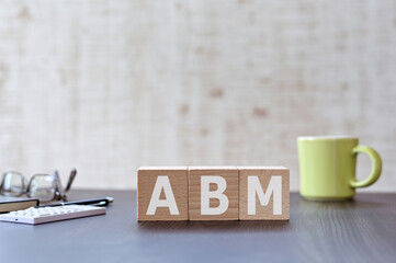 There is wood cube with the word ABM. It is an acronym for Account Based Marketing an eye-catching...