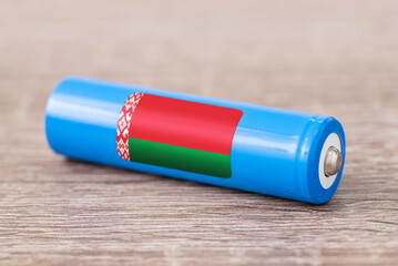 Close up shot of li-ion battery with flag of Belarus on the table. Concept of producing accumulators in Belarus