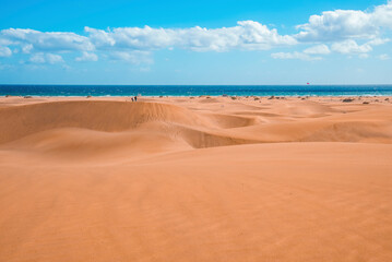 Fototapeta na wymiar Scenic view of Maspalomas sand dunes desert and seascape with cloudy sky at Gran Canaria